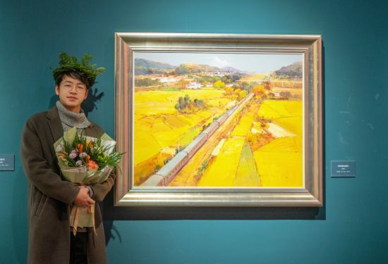朱国举在画作《穿越金秋田野》前留影。 朱国举在画作《穿越金秋田野》前留影。
